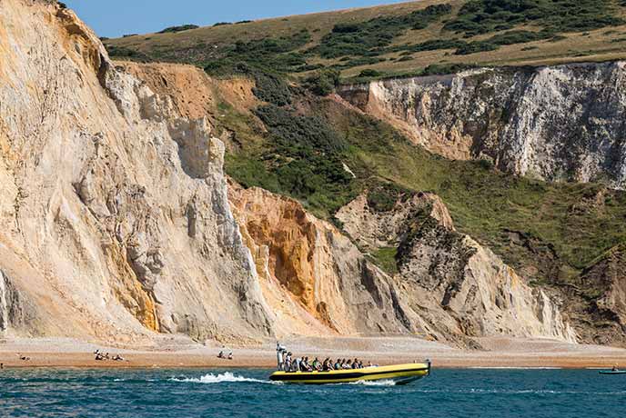 People enjoying a boat trip along Alum Bay on the Isle of Wight